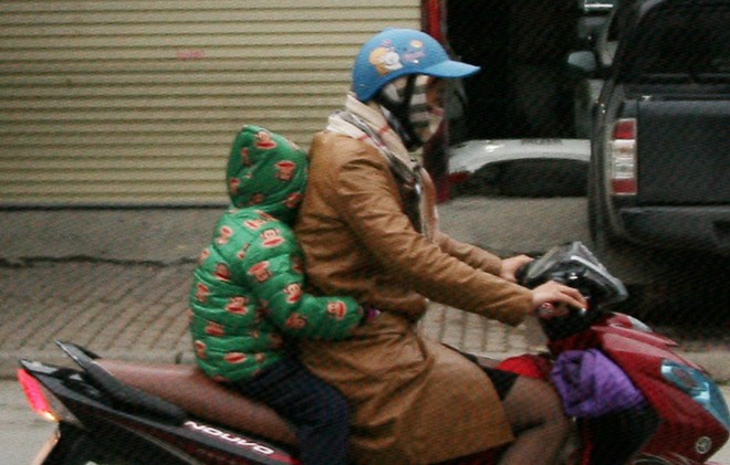 Hà Nội chuyển rét đậm, cha mẹ khoác áo mưa đón con trẻ từ trường về nhà dù trời tạnh ráo - Ảnh 11.
