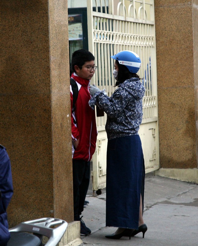 Hà Nội chuyển rét đậm, cha mẹ khoác áo mưa đón con trẻ từ trường về nhà dù trời tạnh ráo - Ảnh 7.
