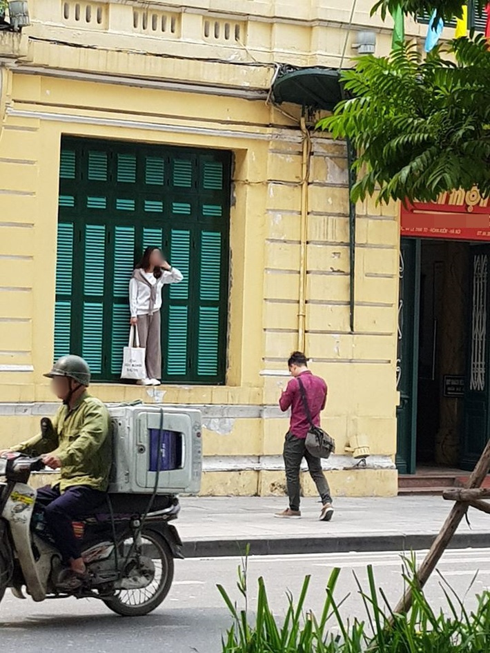 Cô gái trẻ trèo lên cửa sổ nhà cổ Hà Nội để 