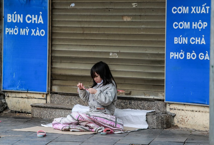 Những ngày Hà Nội vắng vẻ bởi cách ly xã hội, đâu đó nơi góc phố cổ là hình ảnh bé gái lủi thủi trên tấm bìa giấy giữa trời mưa phùn giá rét - Ảnh 3.
