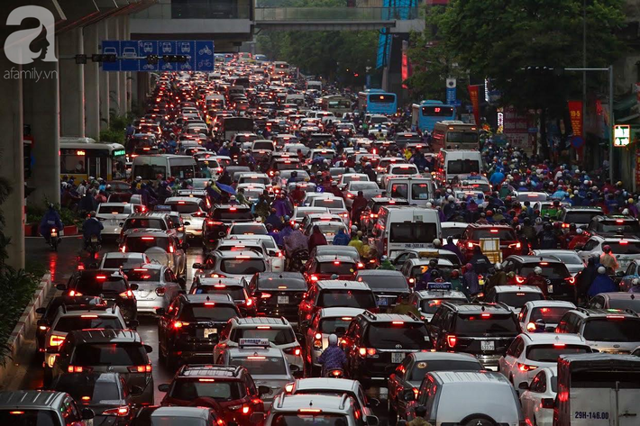 Sau cơn mưa lớn vào sáng sớm, Hà Nội tắc đường kinh hoàng, người dân khổ sở đội mưa đi học, đi làm - Ảnh 9.