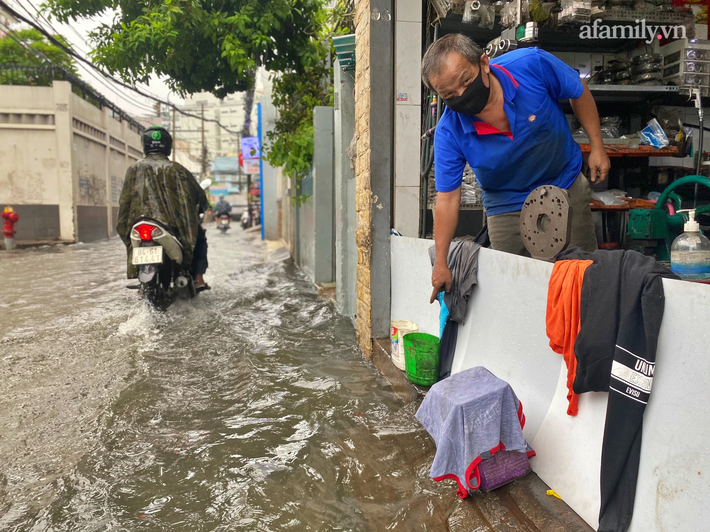 Mưa lớn liên tục nhiều giờ gây ngập sâu, người dân TP.HCM ngao ngán tìm cách chắn cửa ngăn nước tràn vào nhà - Ảnh 8.