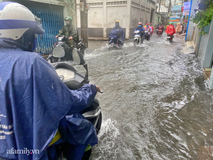 Mưa lớn liên tục nhiều giờ gây ngập sâu, người dân TP.HCM ngao ngán tìm cách chắn cửa ngăn nước tràn vào nhà - Ảnh 9.