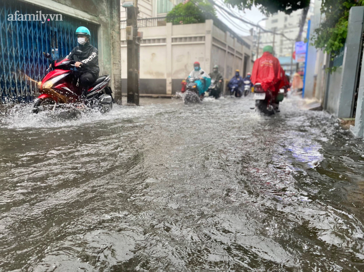 Mưa lớn liên tục nhiều giờ gây ngập sâu, người dân TP.HCM ngao ngán tìm cách chắn cửa ngăn nước tràn vào nhà - Ảnh 10.