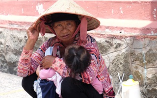 Người người đi lễ trong mùa Phật Đản, riêng em theo mẹ bán hàng rong trước cổng chùa
