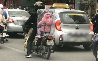 Giữa một sớm mai rét mướt, bức ảnh bé con ngồi sau xe bố trùm kín nilon khiến lòng ta ấm áp