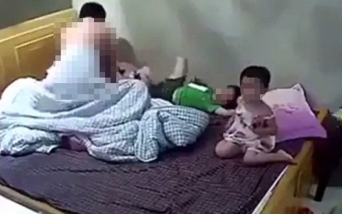 Clip phản cảm: Bật tivi cho 2 con xem, vợ chồng che chăn thản nhiên làm chuyện ấy ngay trước mặt con trẻ