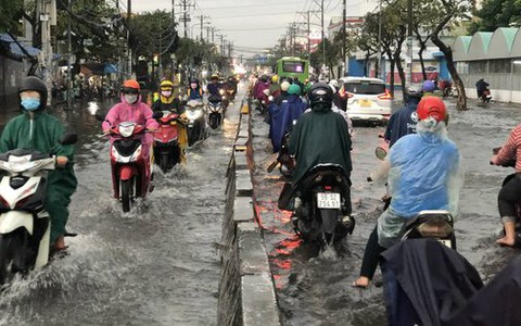 Mưa lớn giờ tan tầm, người dân quận 12, TP HCM bì bõm lội nước về nhà