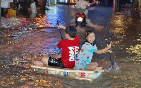Triều cường vượt mức báo động, người dân Cần Thơ cho con bơi bè qua đường đi học