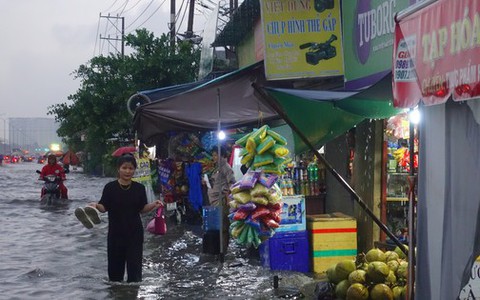 Mưa trắng trời, người dân TPHCM xách dép lội bì bõm trên quốc lộ