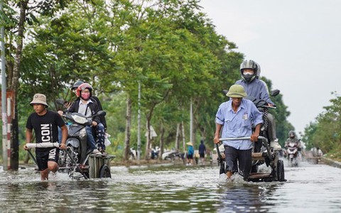 Người dân qua đại lộ Thăng Long bỏ 50.000 đồng/lượt xe bò để ‘vượt ngập’