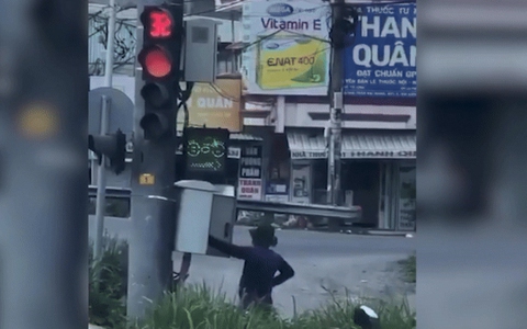 Clip người đàn ông bịt kín mít, đứng bấm đèn giao thông chuyển từ đỏ sang xanh trong "nháy mắt"
