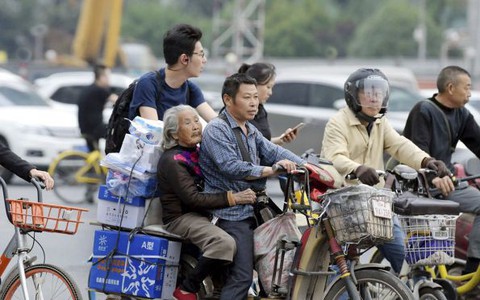 Giữ trọn phận làm con, người giao hàng chở mẹ già trên xe đạp suốt 7 năm, vừa làm việc lại tiện chăm sóc