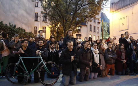 Người dân Paris quỳ xuống, nắm chặt tay nhau đồng lòng hát vang Ave Maria trên đường phố trước khung cảnh hoang tàn của Nhà thờ Đức Bà 