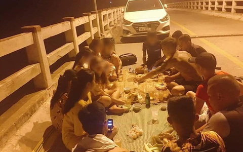 Hình ảnh nhóm thanh niên đỗ ô tô chặn đường, trải chiếu ngồi nhậu trên cầu gây bức xúc