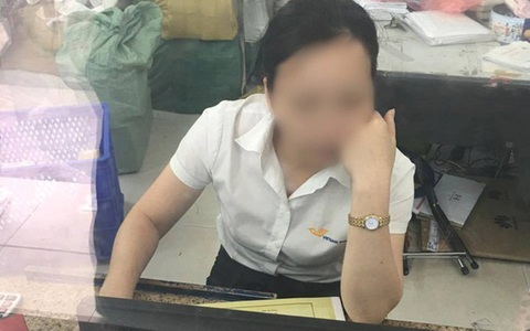 Nhân viên bưu điện ở Hà Nội ngồi chống cằm lướt mạng, thờ ơ với khách hàng